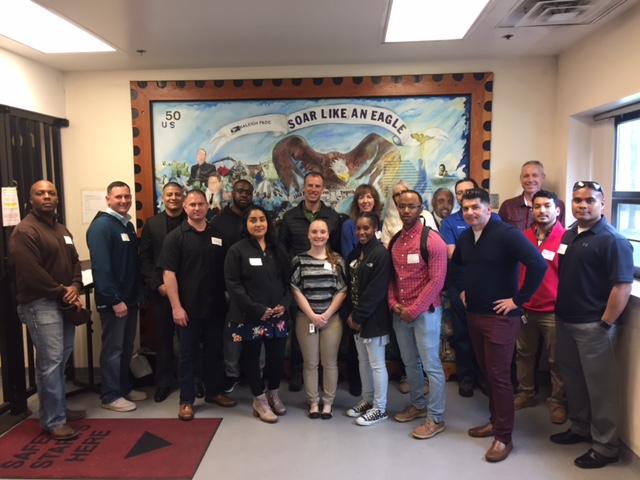 Attendees of PCC Raleigh Plant Tour in front of entrance mural